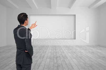 Composite image of asian businessman pointing