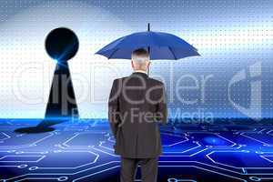 Composite image of businessman holding umbrella