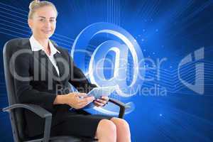 Composite image of businesswoman sitting on swivel chair with ta