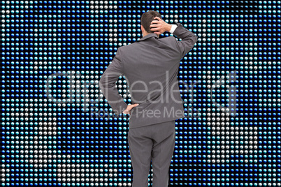 Composite image of young businessman standing back to camera scr