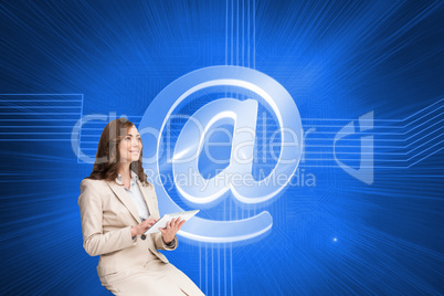 Composite image of businesswoman holding tablet and looking up