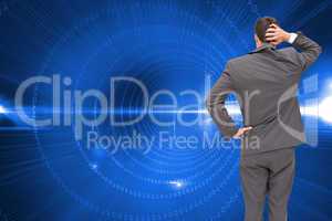 Composite image of young businessman standing back to camera scr