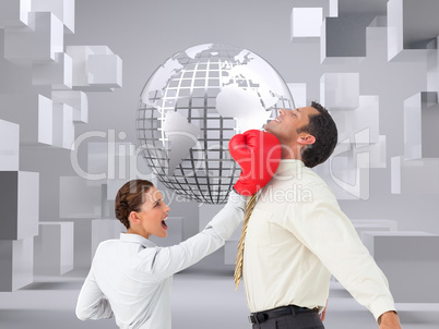 Composite image of businesswoman hitting a businessman with boxi