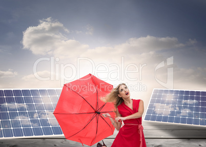 Composite image of elegant blonde holding umbrella