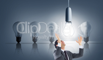 Composite image of happy businessman with arms raised