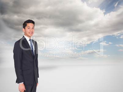 Composite image of smiling businessman looking at camera