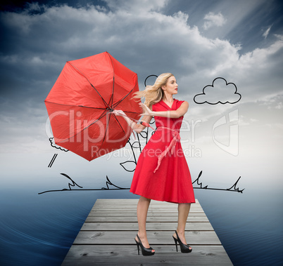 Composite image of beautiful woman posing with a broken umbrella