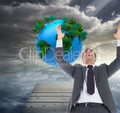 Composite image of excited businessman with arms raised