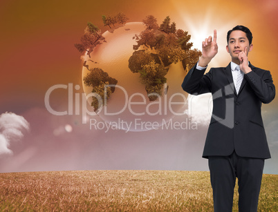 Composite image of thoughtful asian businessman pointing