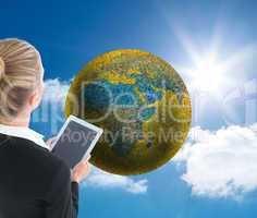 Composite image of businesswoman holding new tablet