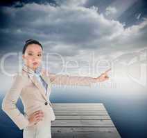 Composite image of unsmiling asian businesswoman pointing