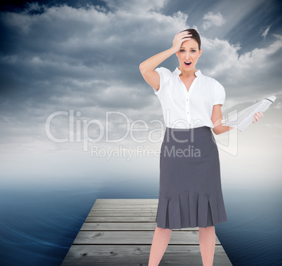 Composite image of shocked classy businesswoman holding newspape