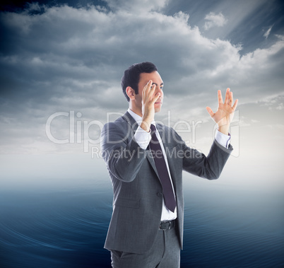 Composite image of unsmiling businessman with arms raised