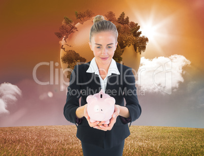 Composite image of businesswoman holding pink piggy bank