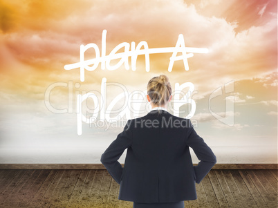 Composite image of businesswoman standing with hands on hips