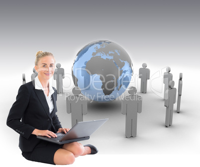 Composite image of businesswoman using laptop