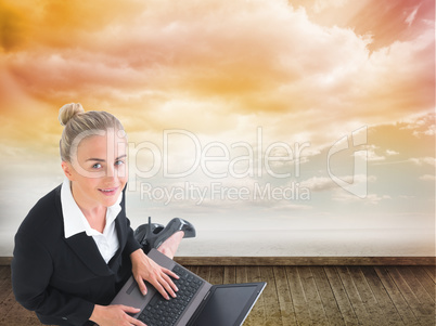 Composite image of businesswoman using laptop