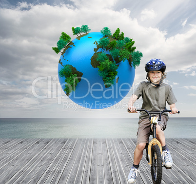 Composite image of little boy with his bike in a park