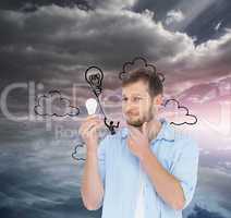Composite image of handsome model holding a bulb