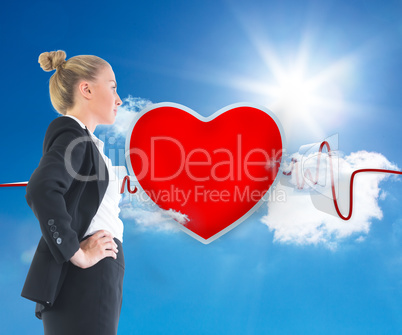 Composite image of businesswoman standing with hands on hips