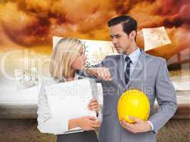 Composite image of architects with plans and hard hat looking at