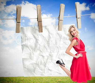 Composite image of smiling blonde standing hands on hips