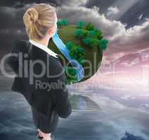 Composite image of businesswoman standing with hands on hips