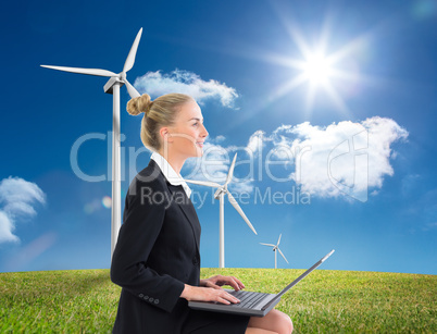 Composite image of businesswoman using laptop