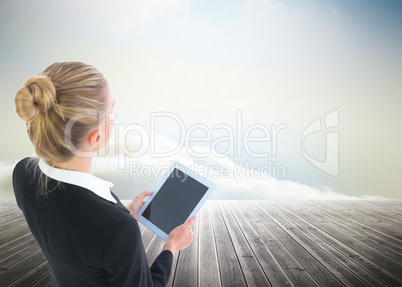 Composite image of businesswoman holding tablet