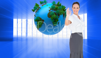 Composite image of elegant businesswoman showing an okay gesture