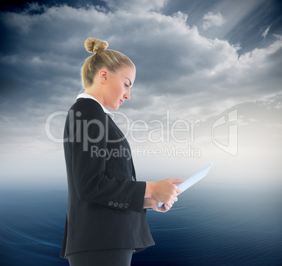 Composite image of businesswoman holding tablet