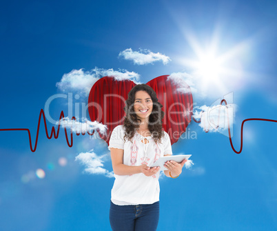 Composite image of smiling casual brunette using her tablet pc