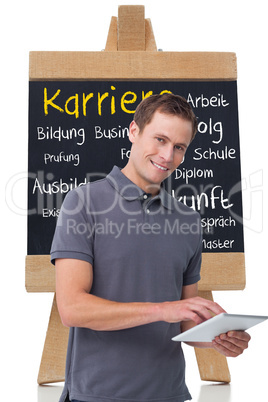 Composite image of smiling young man with tablet computer