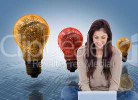 Composite image of brunette sitting on floor using laptop