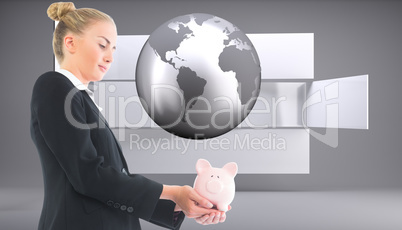 Composite image of businesswoman holding piggy bank