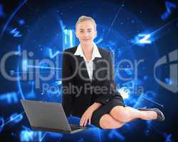 Composite image of businesswoman using laptop