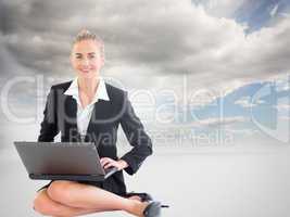 Composite image of businesswoman using laptop