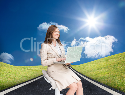 Composite image of smiling businesswoman sitting and using lapto