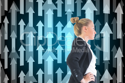 Composite image of businesswoman standing with hands on hips