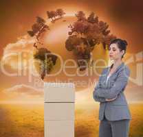 Composite image of thoughtful woman with cardboard boxes