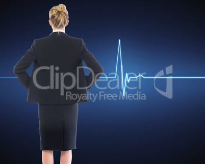 Composite image of businesswoman standing with hands on hips