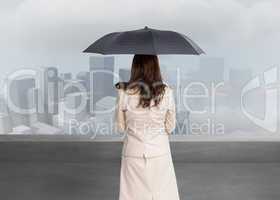 Composite image of rear view of classy businesswoman holding umb