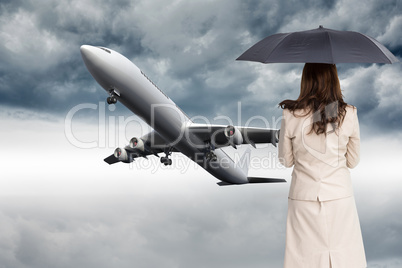 Composite image of rear view of classy businesswoman holding umb