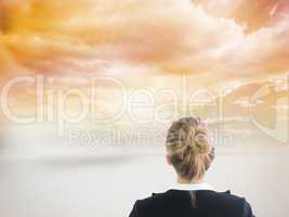 Composite image of businesswoman standing with hands on hips