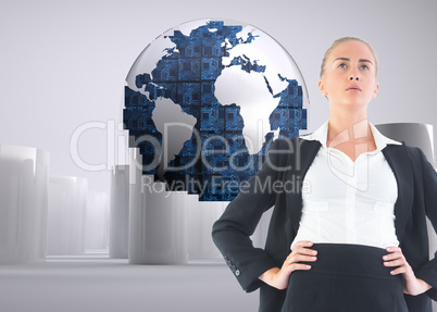 Composite image of businesswoman standing with hands on hips