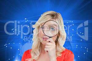 Composite image of fair-haired woman looking through a magnifyin