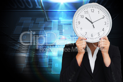 Composite image of businesswoman in suit holding a clock