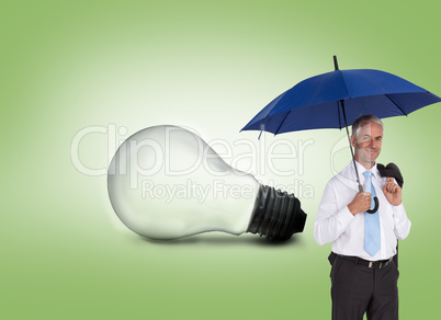 Composite image of happy businessman holding umbrella