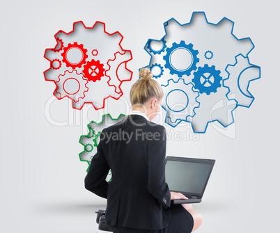 Composite image of businesswoman using laptop