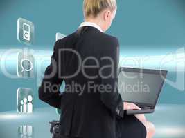 Composite image of businesswoman using laptop